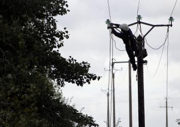 An electric company worker repairs damaged power lines damaged northwestern France.