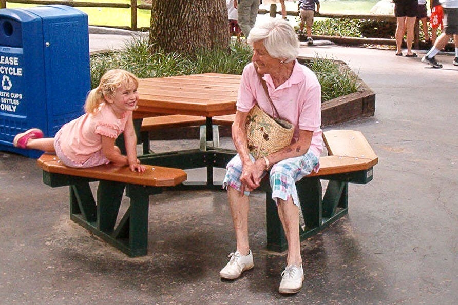 More recent photo of Alice on a picnic bench with a child.
