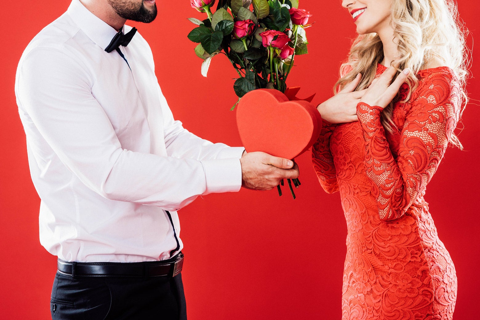 Man giving a woman chocolates and flowers for Valentine's Day.