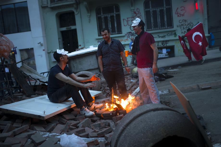 Protesters warmup as they sit on a makeshift barricade near Turkish prime minister Recep Tayyip Erdogan's office, between Taksim and Besiktason June 4, 2013 in Istanbul, Turkey.