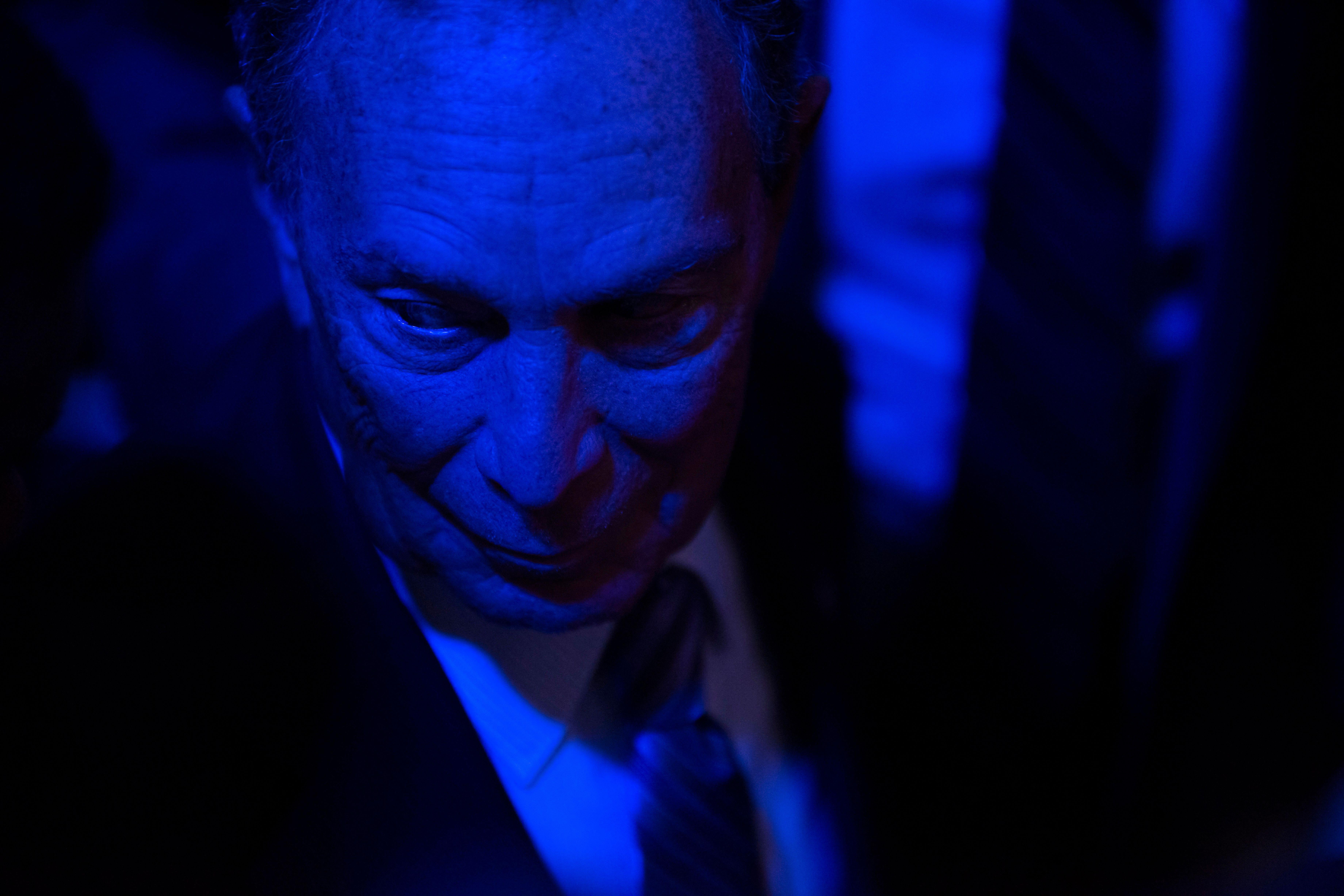 Close shot of Bloomberg in a dark room.