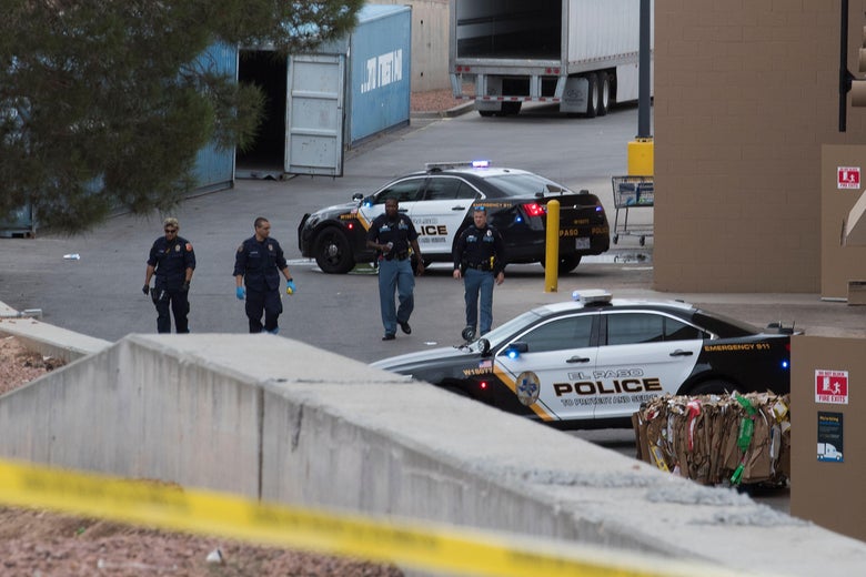 Police cars and law enforcement officials at the crime scene.