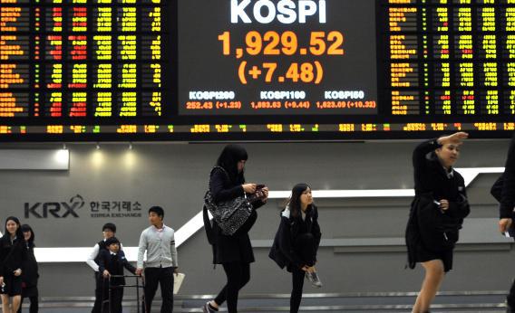 High school students walk past a stock index board as they visit the Korea Stock Exchange in Seoul.