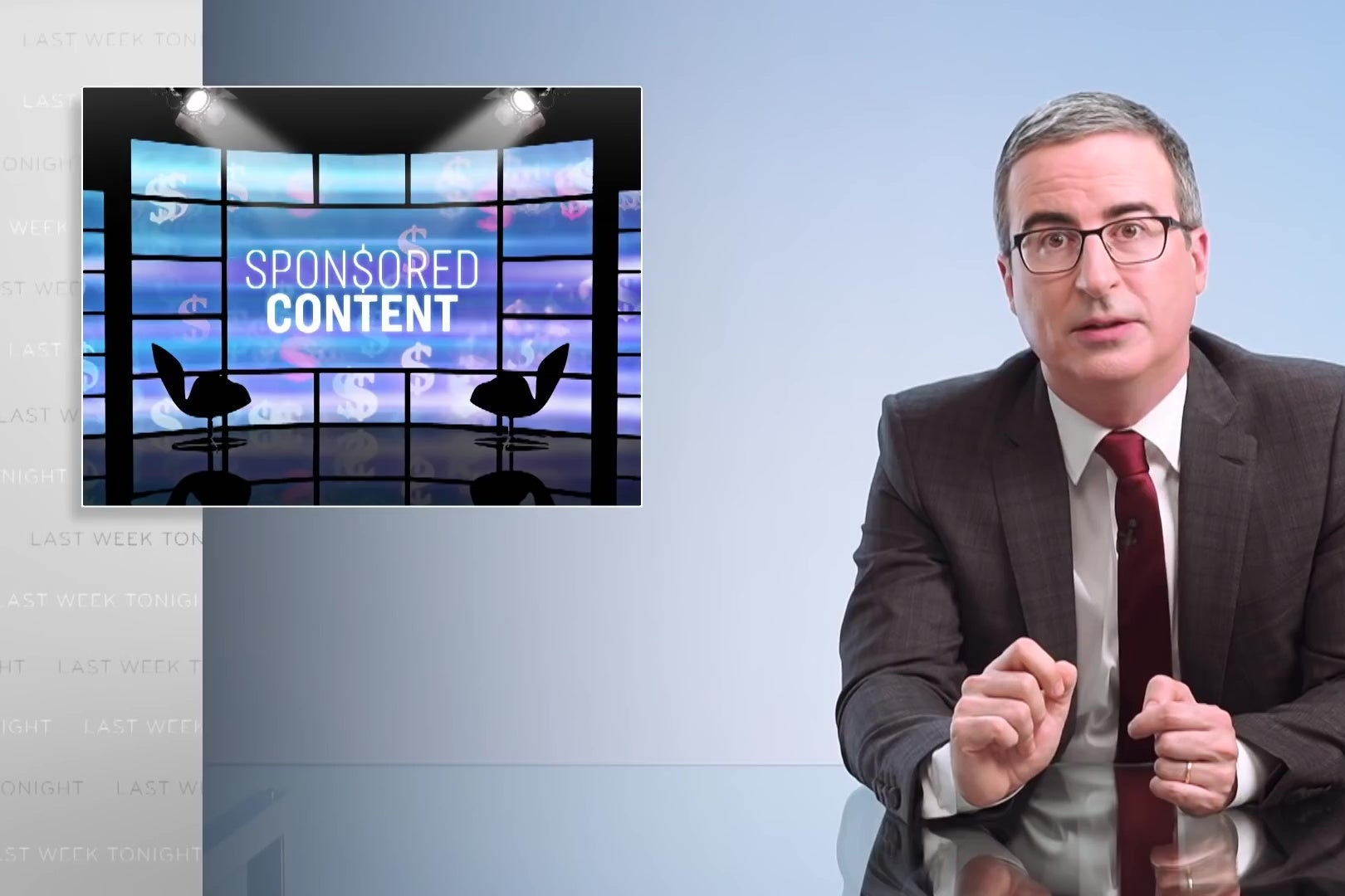 John Oliver sits at his glass anchor desk in front of a chyron reading "SPON$ORED CONTENT."