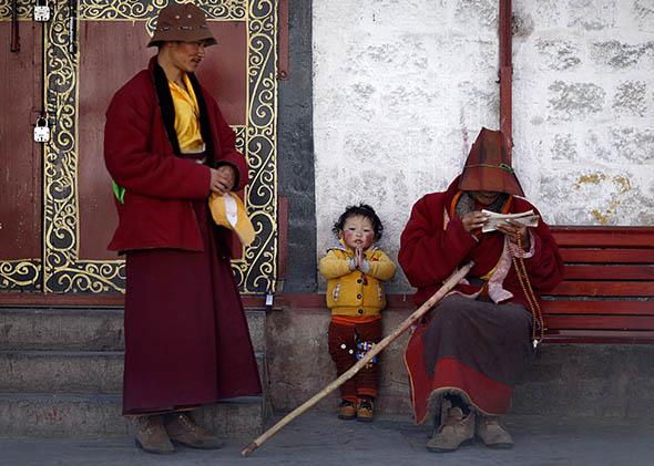 A Tibetan family rests outside Jokhang Monastery in Lhasa, Tibet, on March 4, 2014.