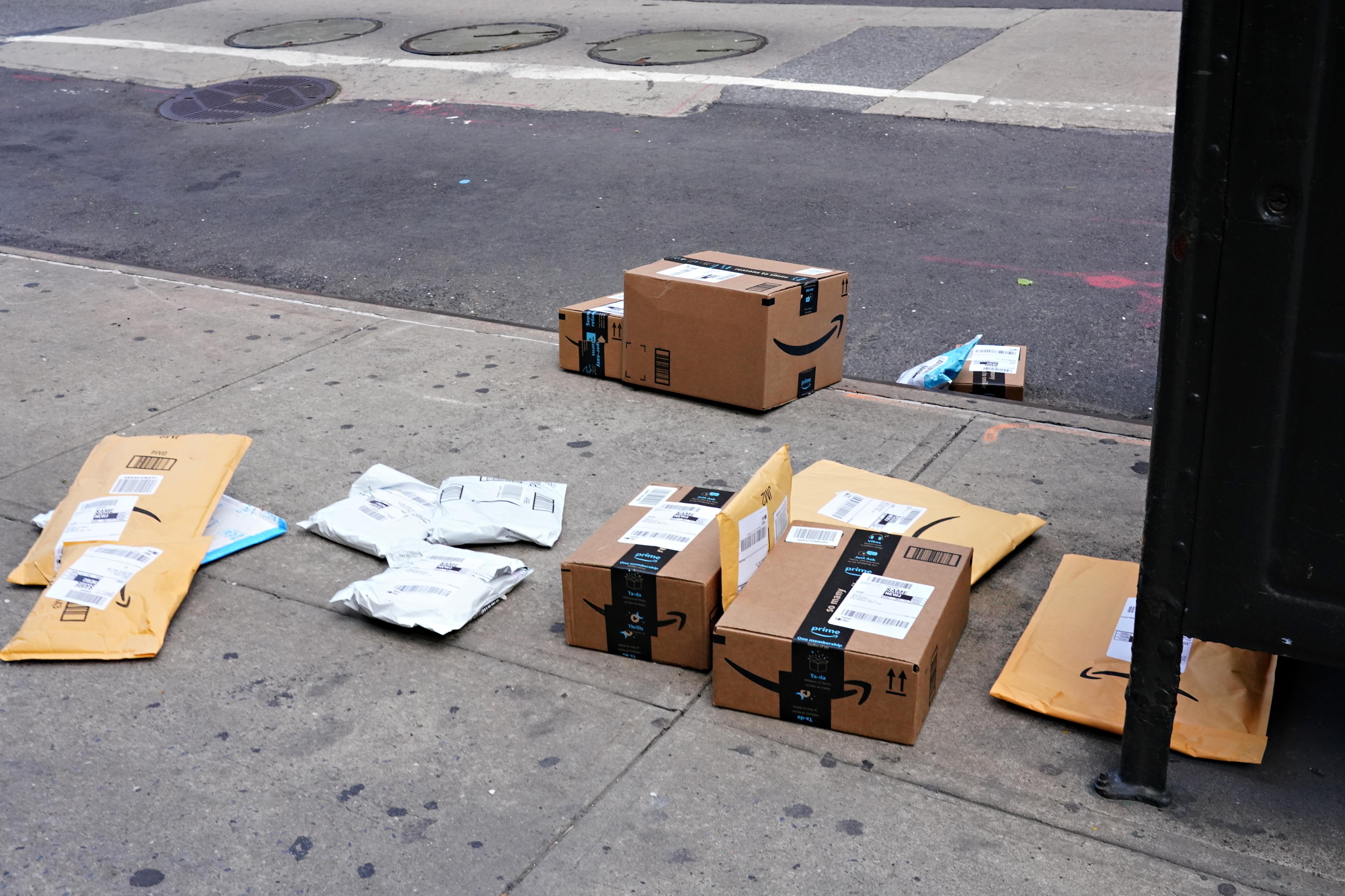 Amazon packages strewn across a city sidewalk.