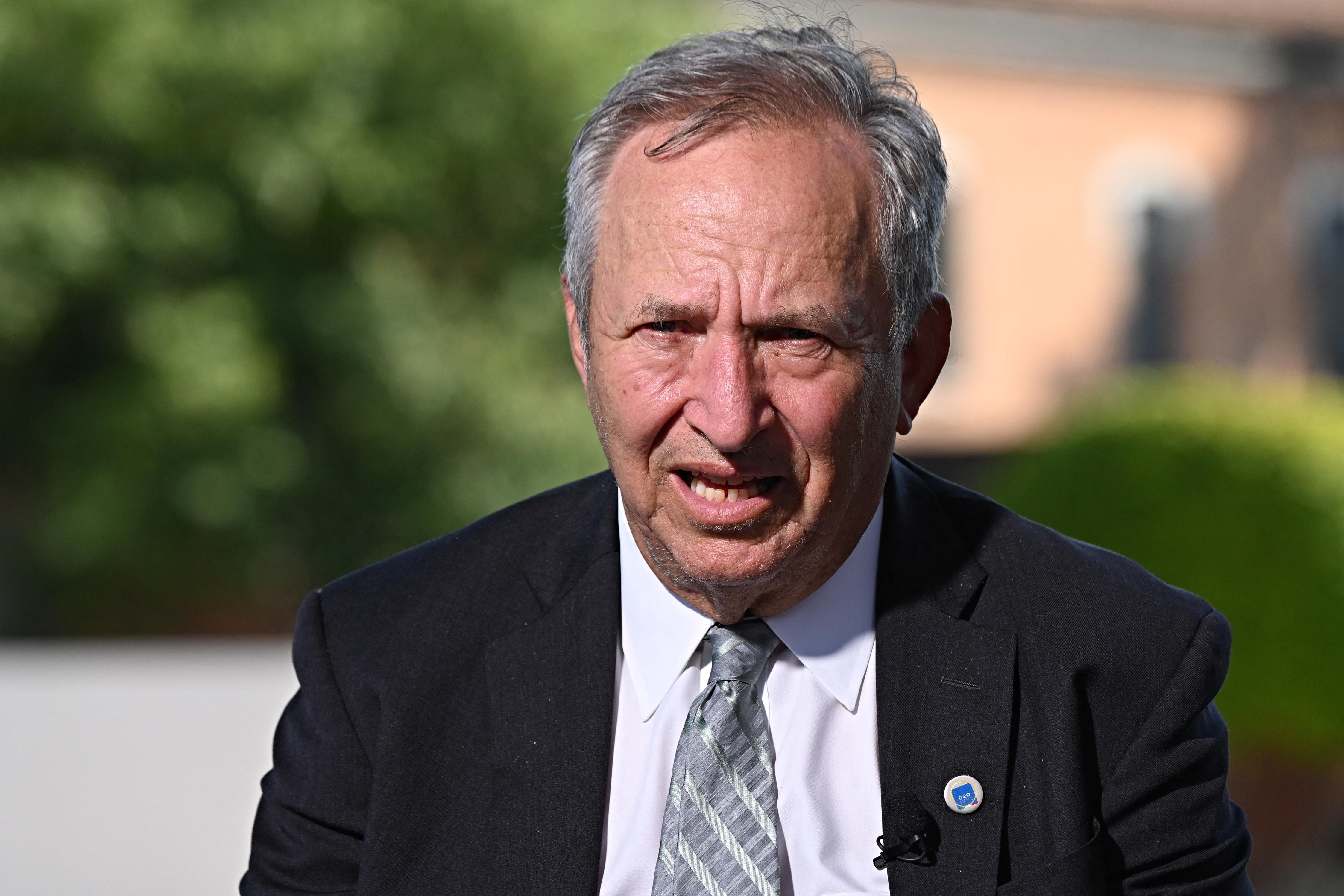 Larry Summers, outdoors looking at the camera as he speaks.