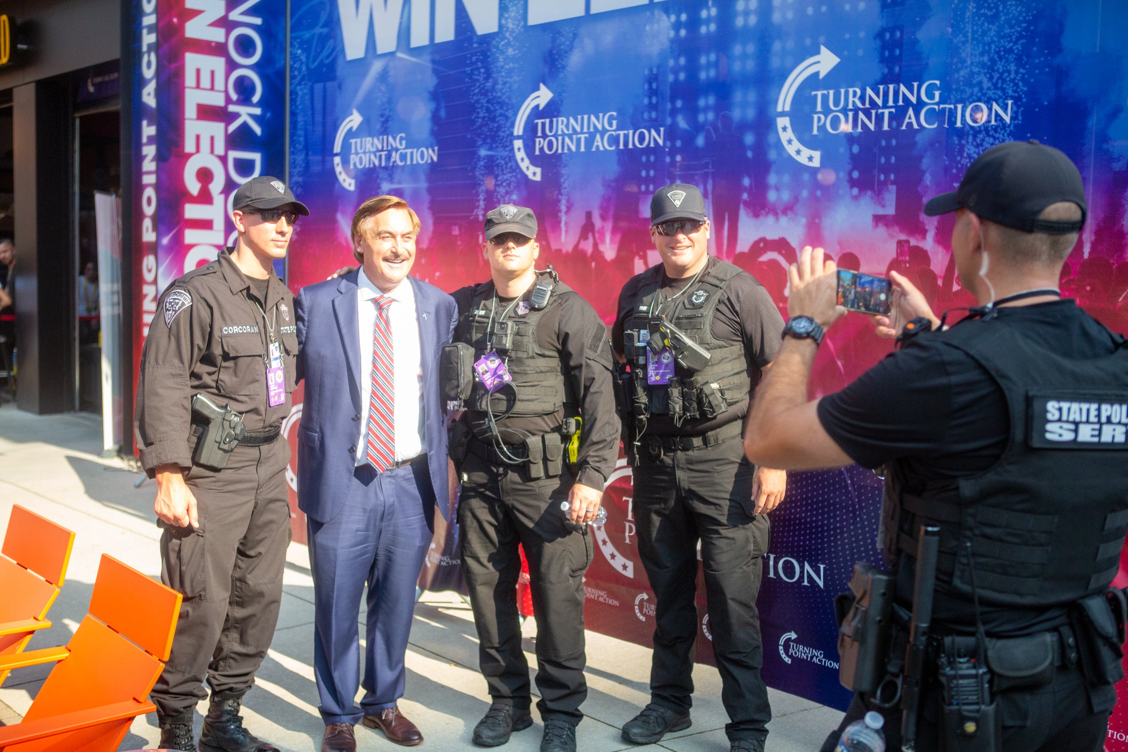 Cops take a photograph with Mike Lindell at the RNC. 