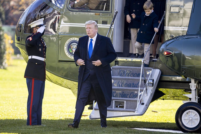 Trump walks away from Marine One on the South Lawn of the White House, past a uniformed service member saluting him.