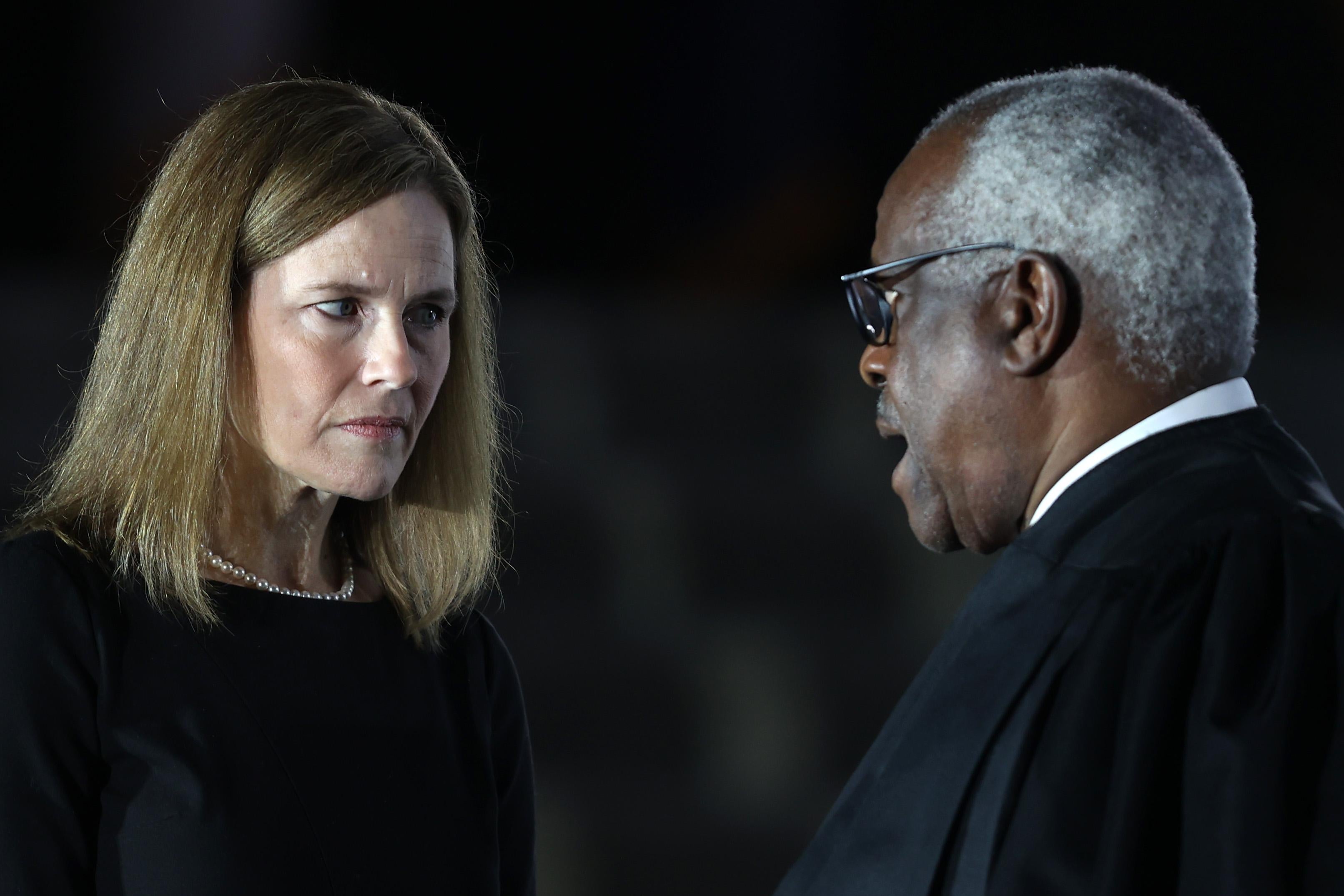 Judge Amy Coney Barrett talks with Supreme Court Associate Justice Clarence Thomas during her ceremonial swearing-in ceremony to be U.S. Supreme Court Associate Justice, on the South Lawn of the White House October 26, 2020 in Washington, 