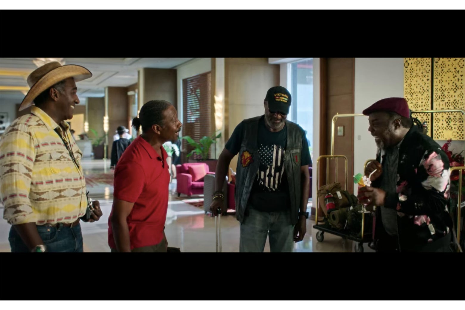 A scene from Da 5 Bloods showing four men at an airport