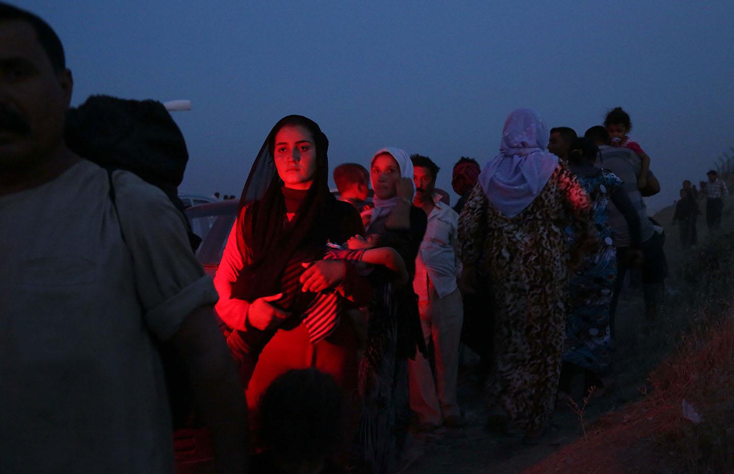 Thousands of Iraqis flee from Sinjar, near the city of Mosul, to Erbil and Dohuk, after armed ISIS groups seized the town early on August 4, 2014. 