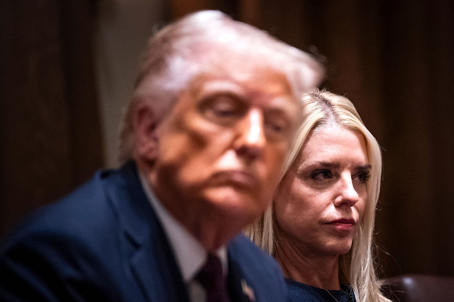 Donald Trump blurry in the foreground, Pam Bondi in the background.