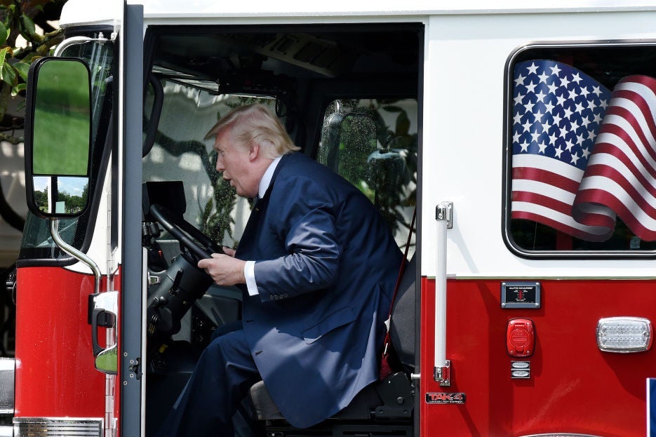 Trump leans forward in the cab while apparently making some sort of noise with his mouth.