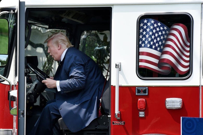 Trump leans forward in the cab while apparently making some sort of noise with his mouth.