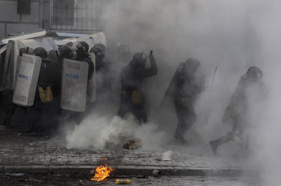 Government police take cover behind shields during clashes with protesters in Kiev on Feb. 18, 2014. 
