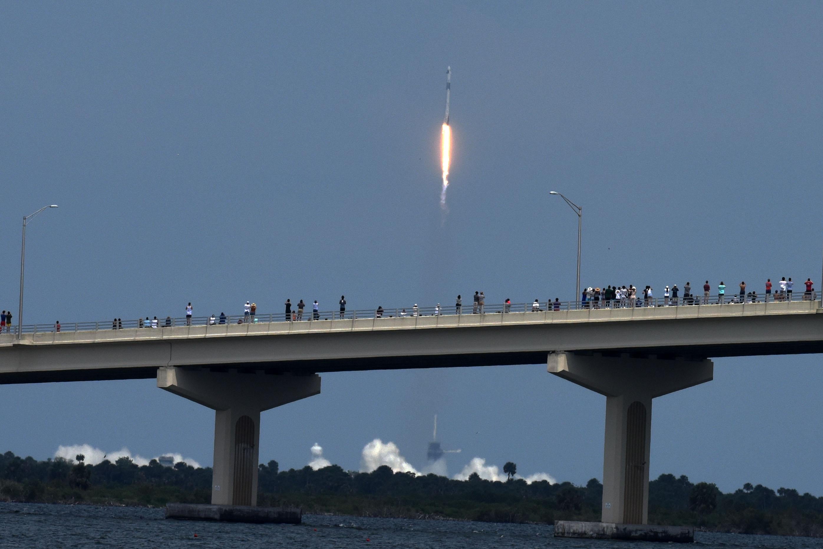 People line the A.Max Brewer Causeway to watch the launch of a SpaceX Falcon 9 rocket from Cape Canaveral, Florida May 30, 2020 in Titusville, Florida.