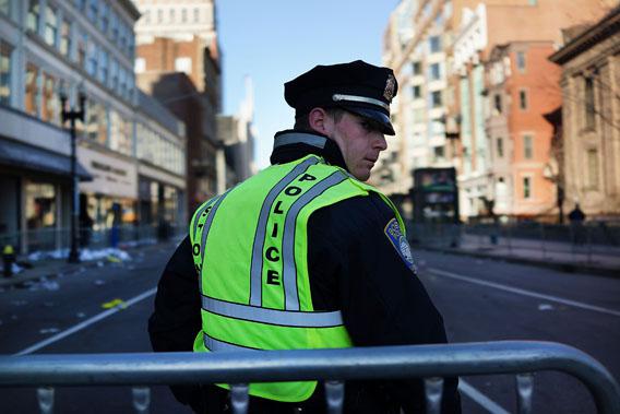 A Boston police officer stands near the scene of a twin bombing at the Boston Marathon on April 16, 2013 in Boston, Massachusetts. 