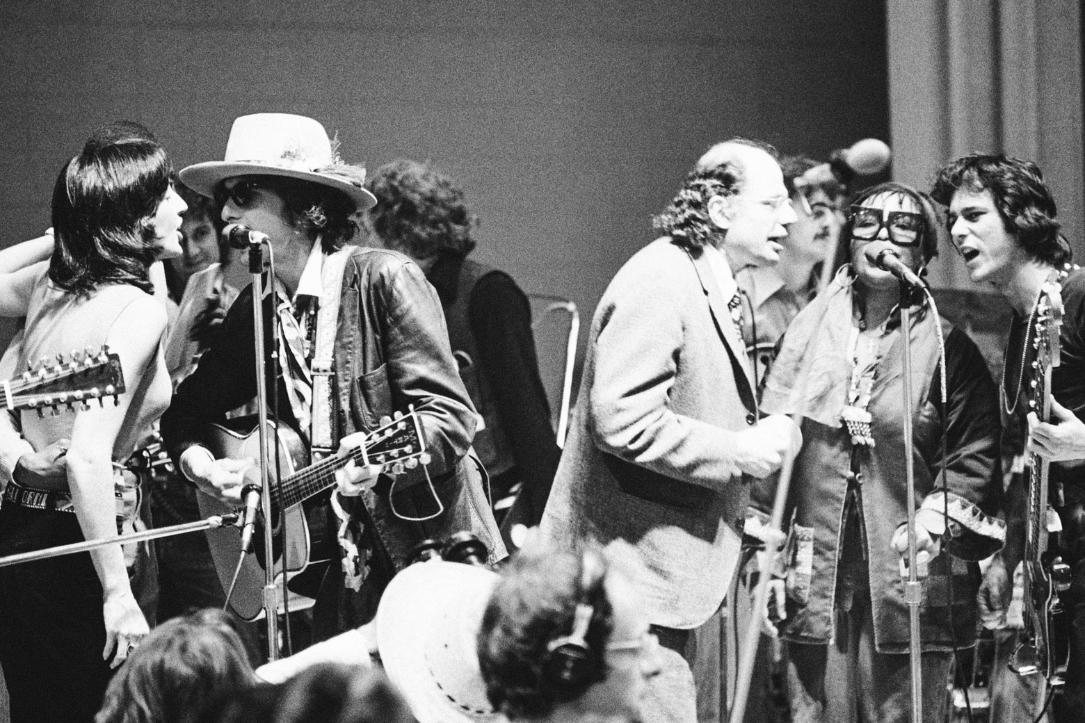 Baez and Dylan sing into one mic as Ginsberg and Flack sing into another during a performance