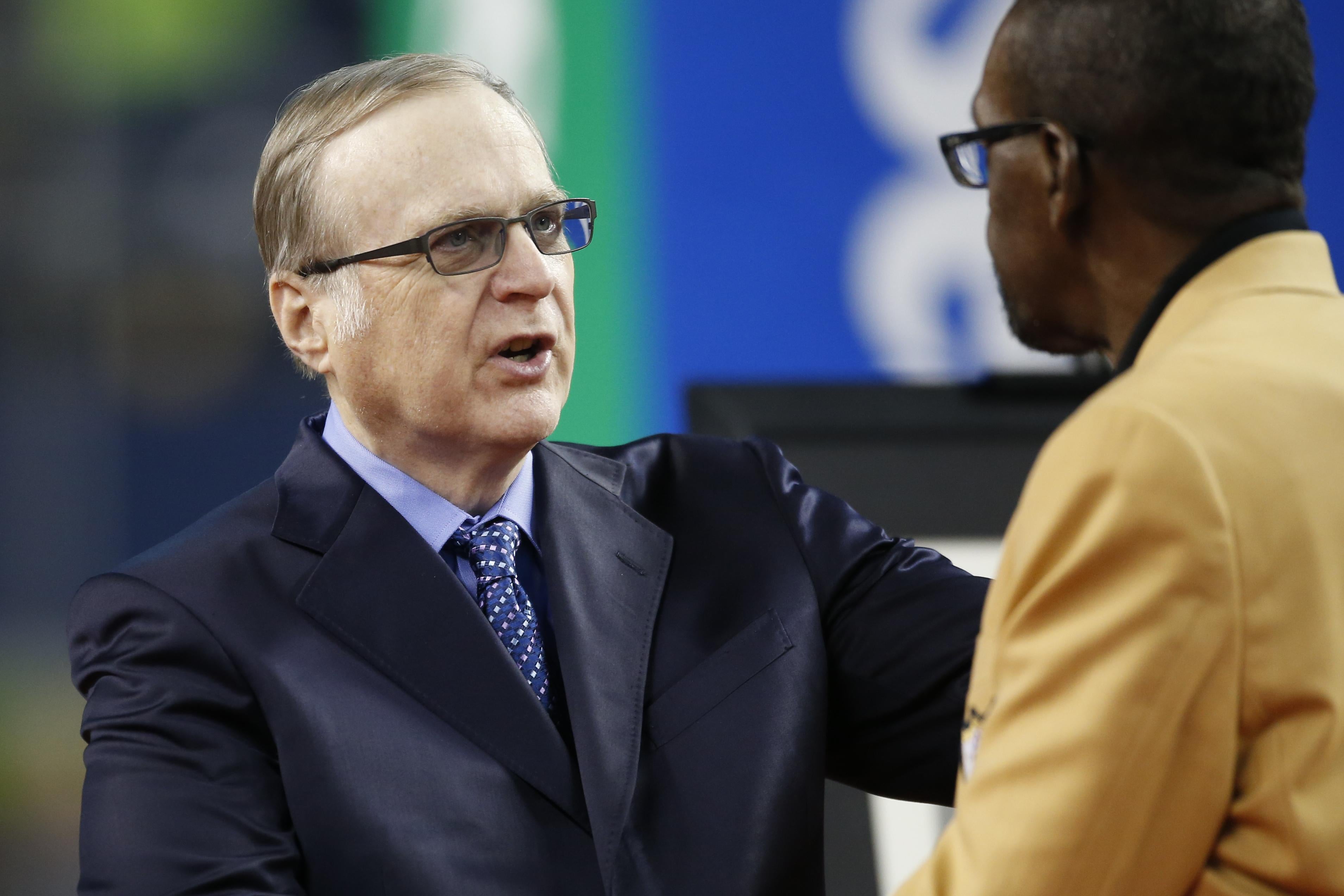 Paul Allen greets an NFL Hall of Fame member during halftime of a Seahawks game.