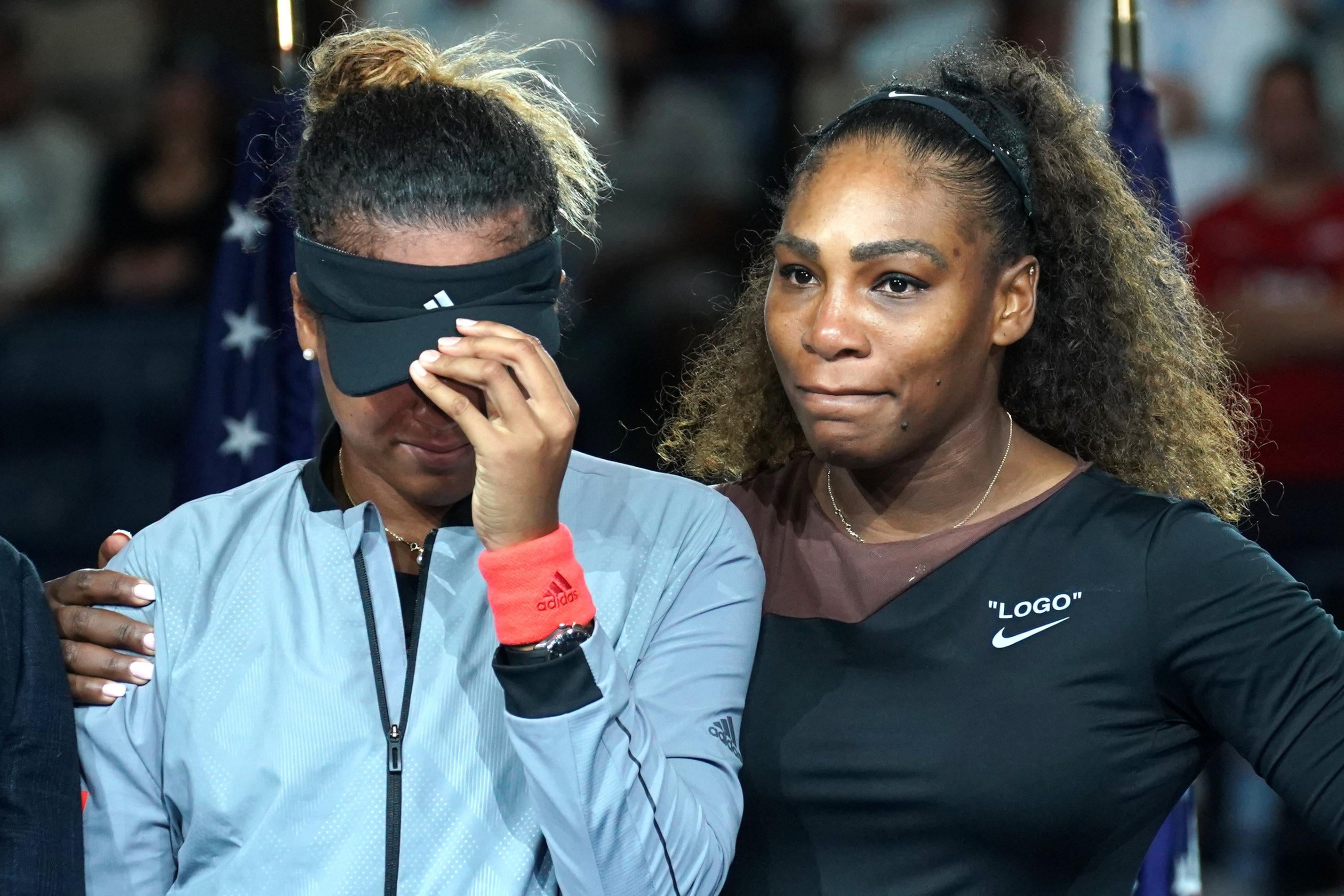 The victor Naomi Osaka of Japan (L) stands beside the defeated Serena Williams of the US following their Women's Singles Finals match at the 2018 US Open at the USTA Billie Jean King National Tennis Center in New York on September 8, 2018. - Osaka, 20, triumphed 6-2, 6-4 in the match marred by Williams's second set outburst, the American enraged by umpire Carlos Ramos's warning for receiving coaching from her box. She tearfully accused him of being a 'thief' and demanded an apology from the official. (Photo by TIMOTHY A. CLARY / AFP)        (Photo credit should read TIMOTHY A. CLARY/AFP/Getty Images)