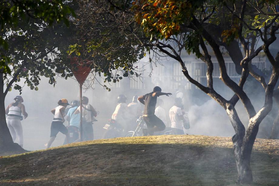 Opposition demonstrators run away from tear gas during a protest against President Nicolas Maduro's government in Caracas February 16, 2014.