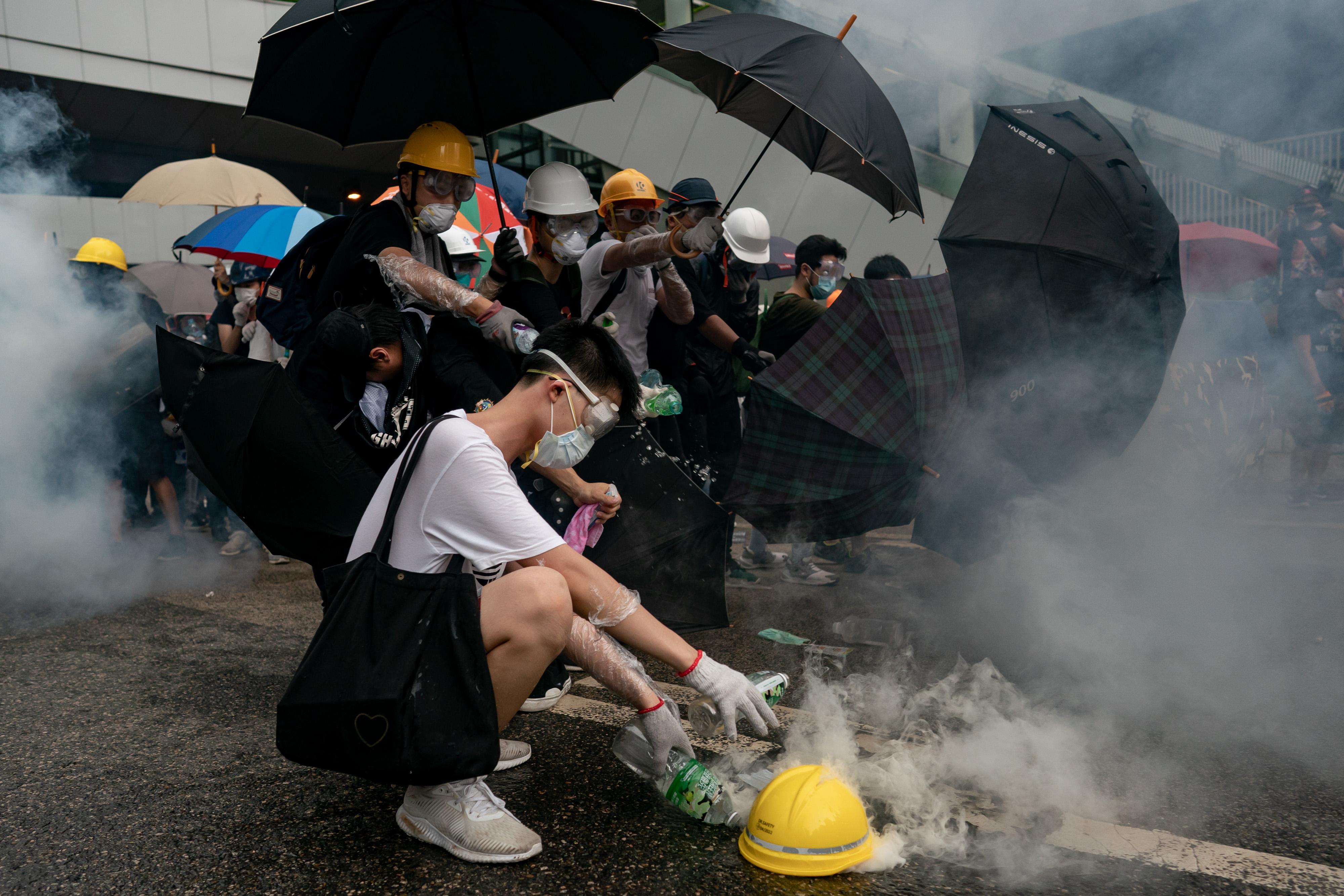 Protesters pour water on a tear gas canister in Hong Kong.