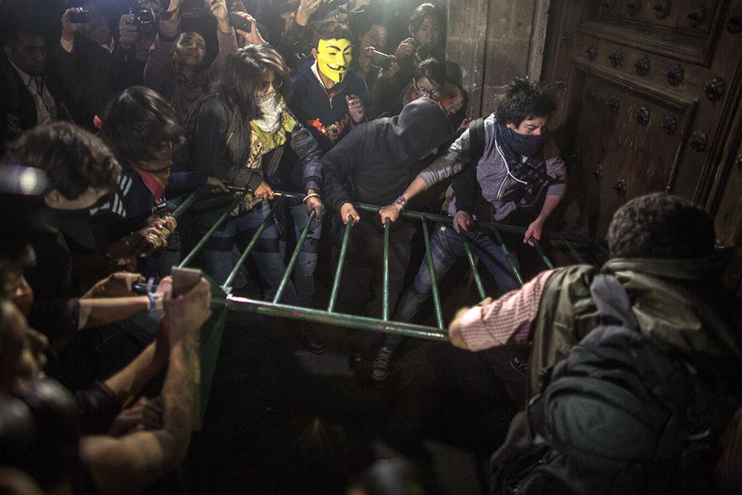 Demonstrators try to knock down the door of Mexico's Government Palace during a demonstration on November 8 in Mexico City.