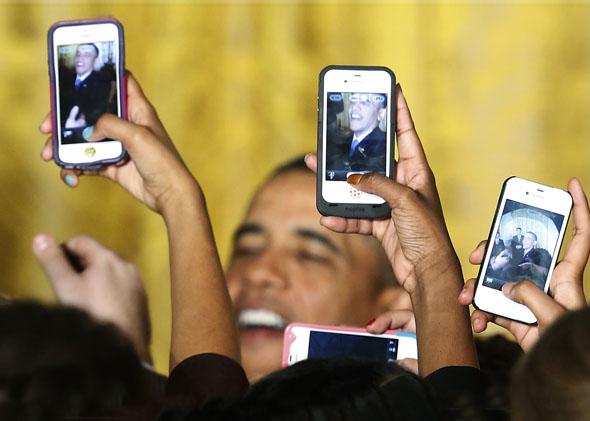 Attendees photograph President Obama with their mobile phones at a Women's History Month reception at the White House in Washington, March 18, 2013.