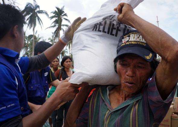 Locals queue for aid from international charity World Vision in an area damaged by Typhoon Haiyan in November 2013.