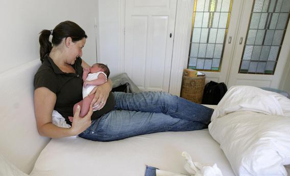 Mother Susan Veenhoff sits in bed with her newborn Maarten Rammeloo, who was born at home in Amsterdam