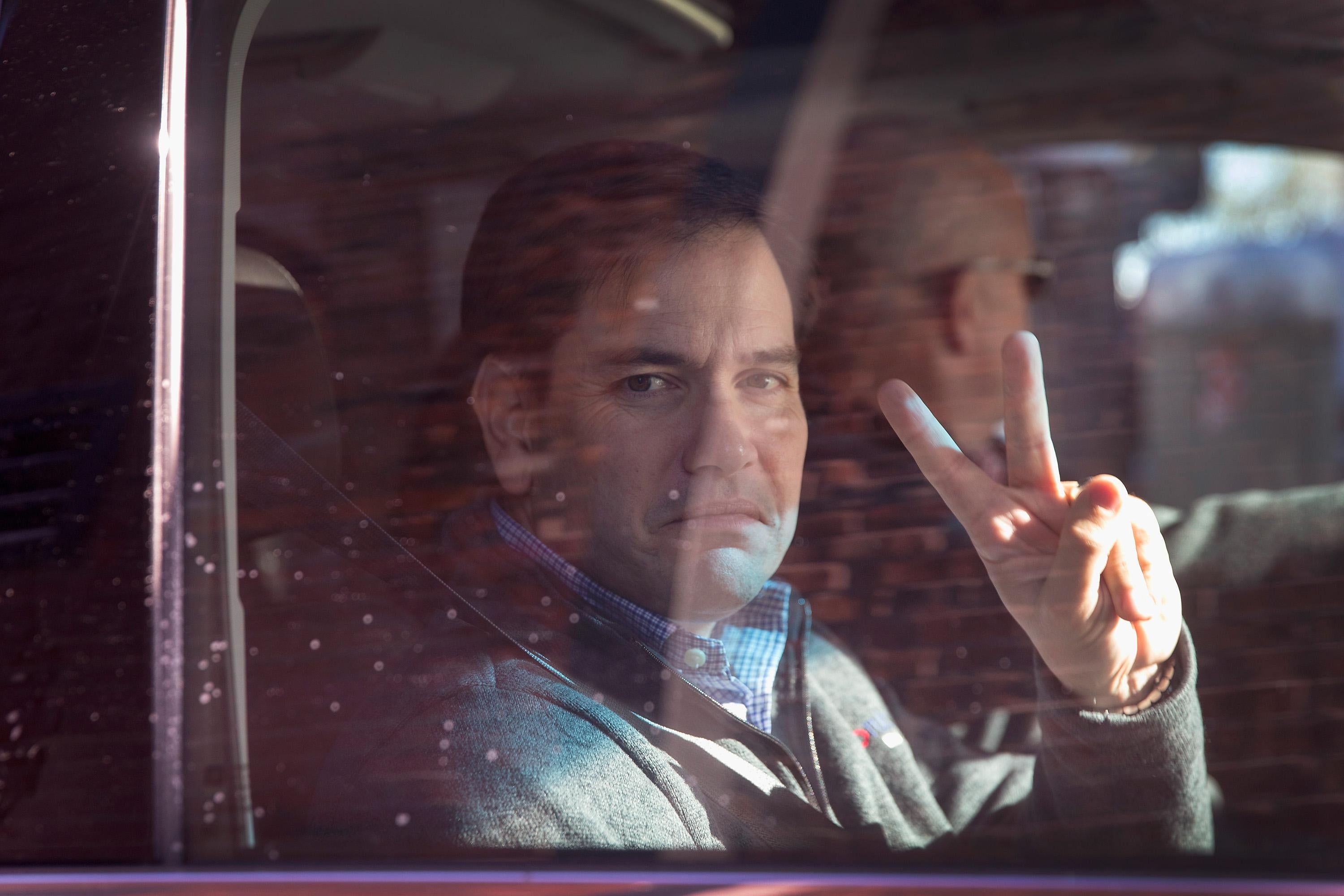 Rubio gives the peace symbol through the window.