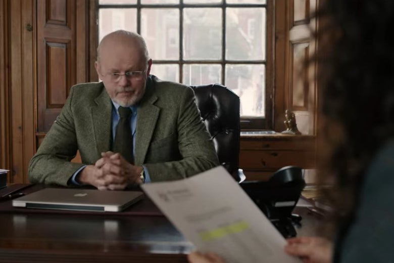 Pembroke's dean sits in a leather chair at a desk.