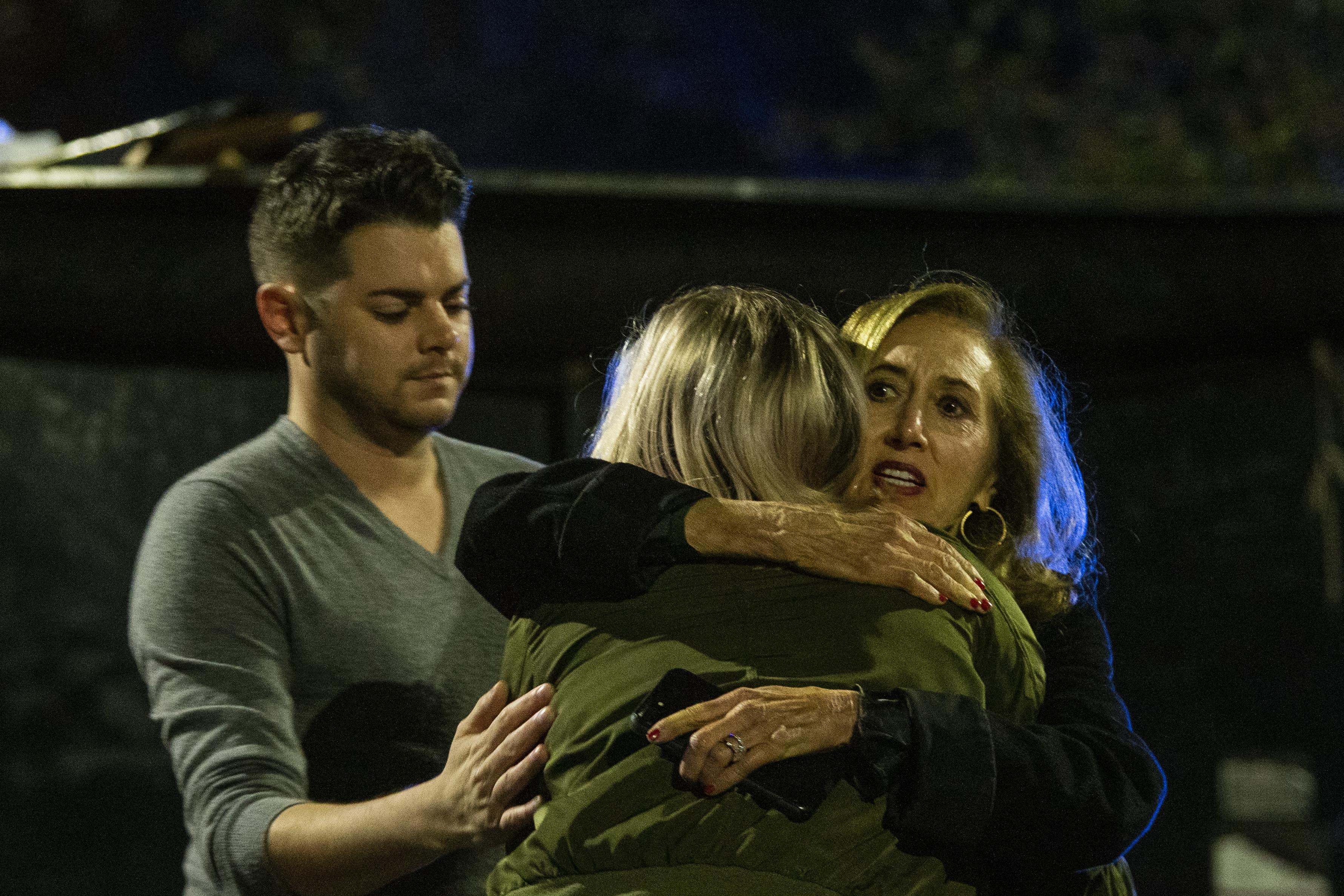 Matthew Rodin, left and Susan Turner comfort Melissa Hutchinson who rendered aid to some of the victims of a mass shooting November 2, 2018 in Tallahassee, Florida. 