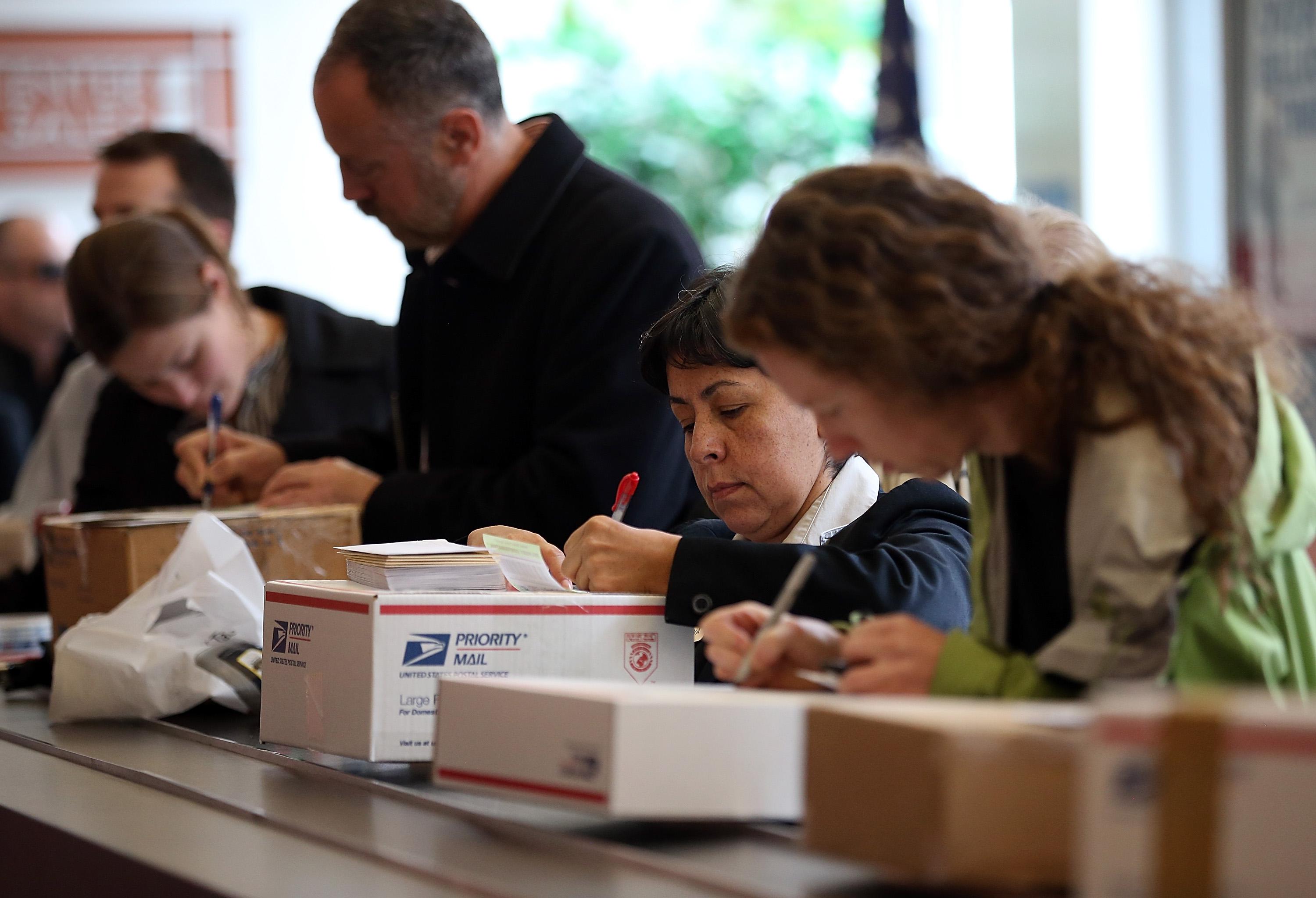 Customers fill in address information on packages at the United States Post Office at Rincon Center on Dec. 17, 2012, in San Francisco.