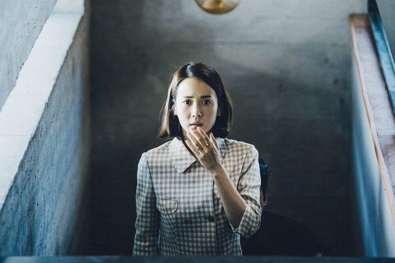A woman ascends a set of stairs, her hand over her mouth.
