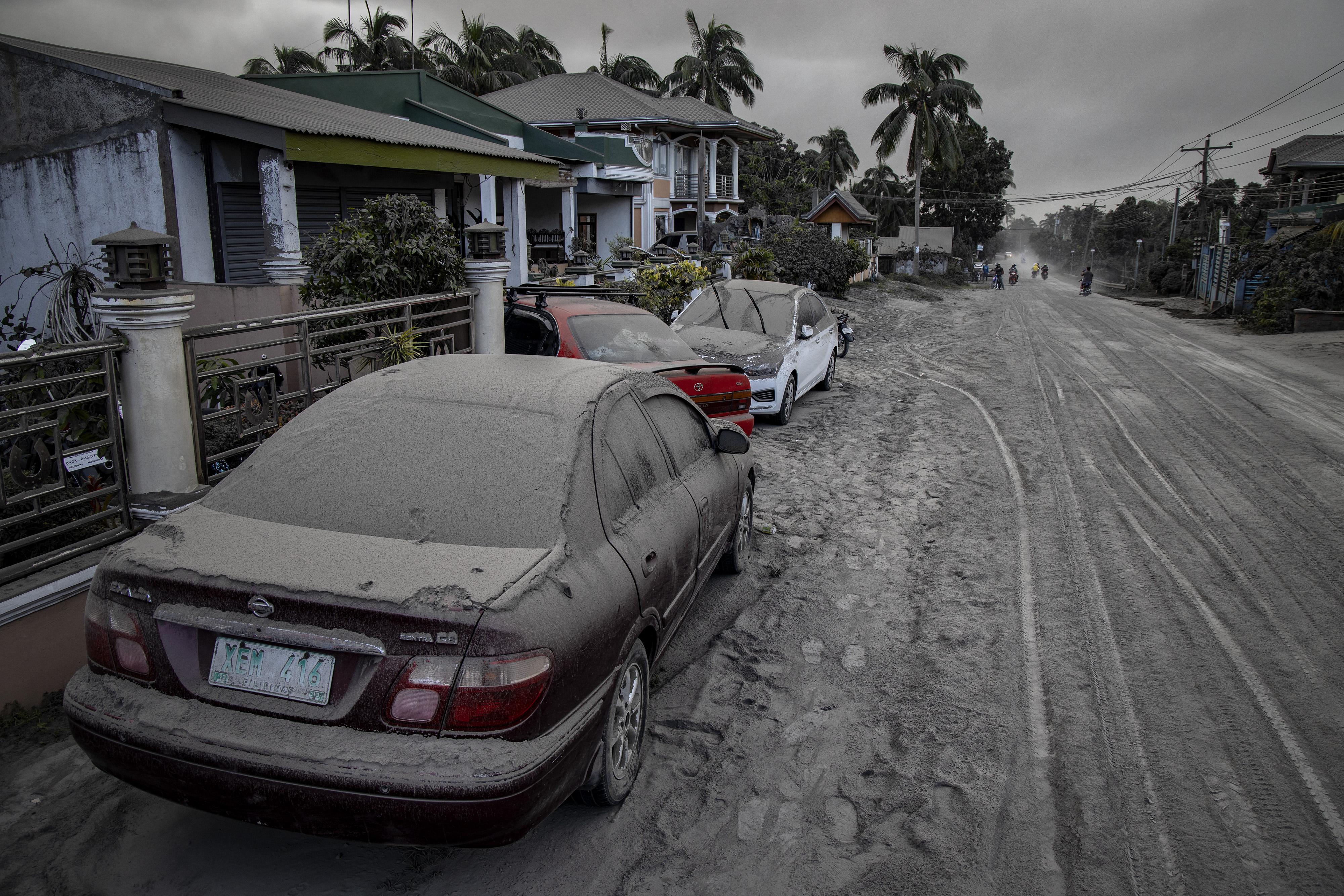 Cars and a road covered in ash.