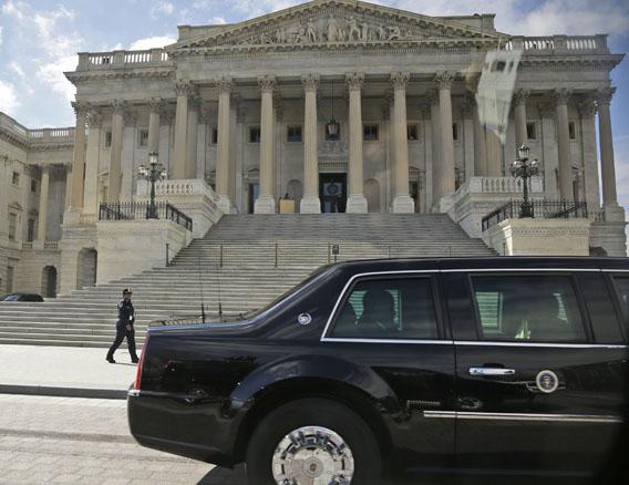 President Barack Obama is seen inside his vehicle leaving the US Capitol in Washington, Tuesday, March 12, 2013. 