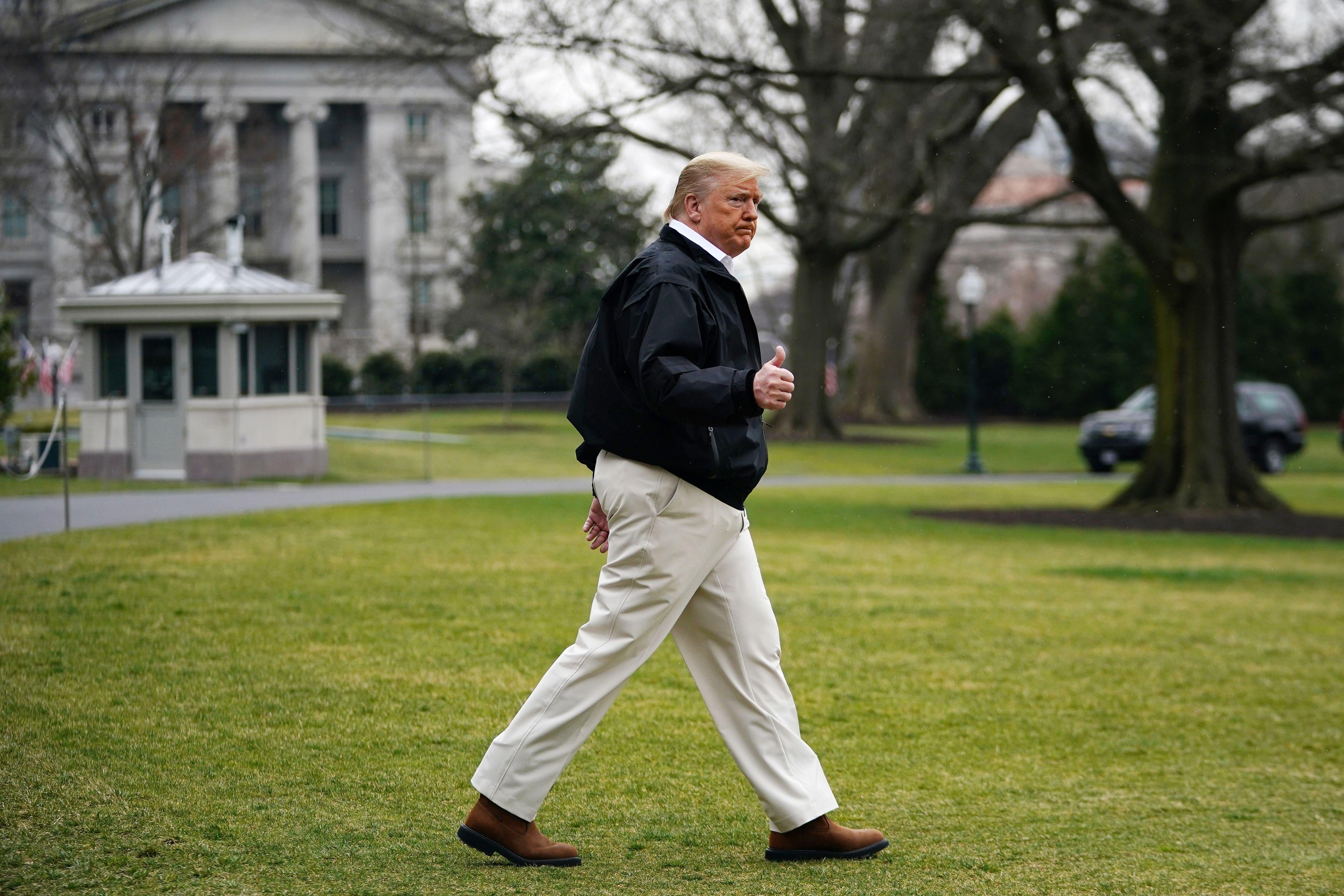 Trump makes a thumbs-up as he walks across the South Lawn