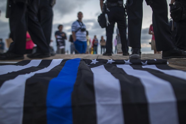 A "thin blue line" flag seen close up, on the ground.