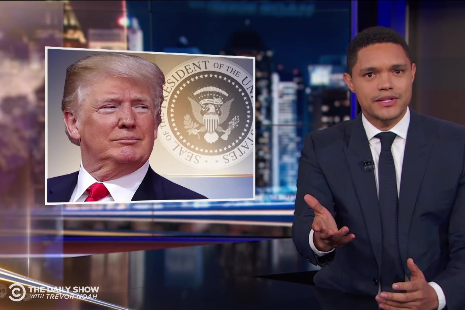 Trevor Noah with a picture of Donald Trump.