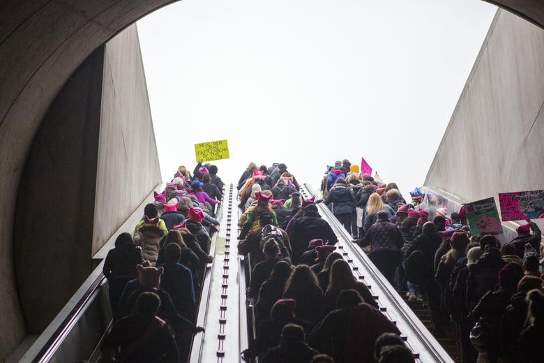 A crowd of protesters take the escalator up from a Washington DC metro station to join the Women's March on January 21, 2017.