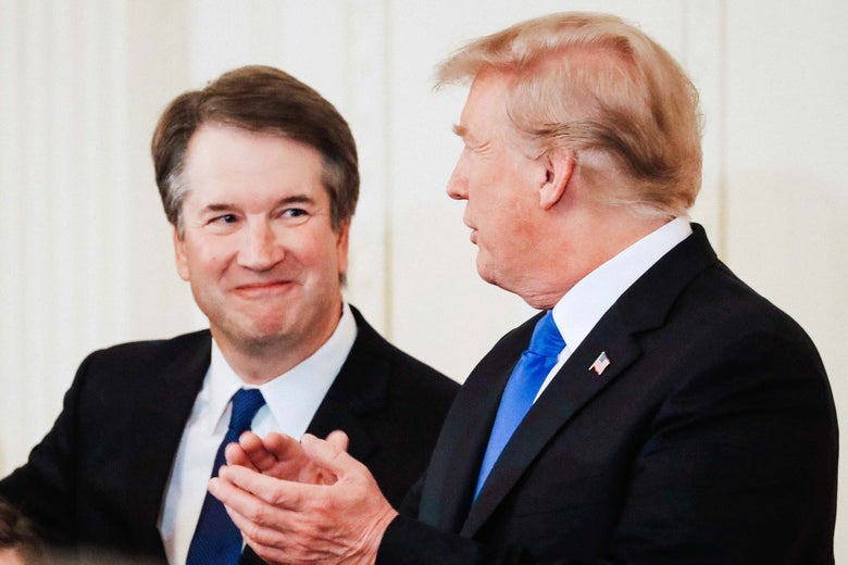Brett Kavanaugh smiles at Donald Trump, who is clapping.