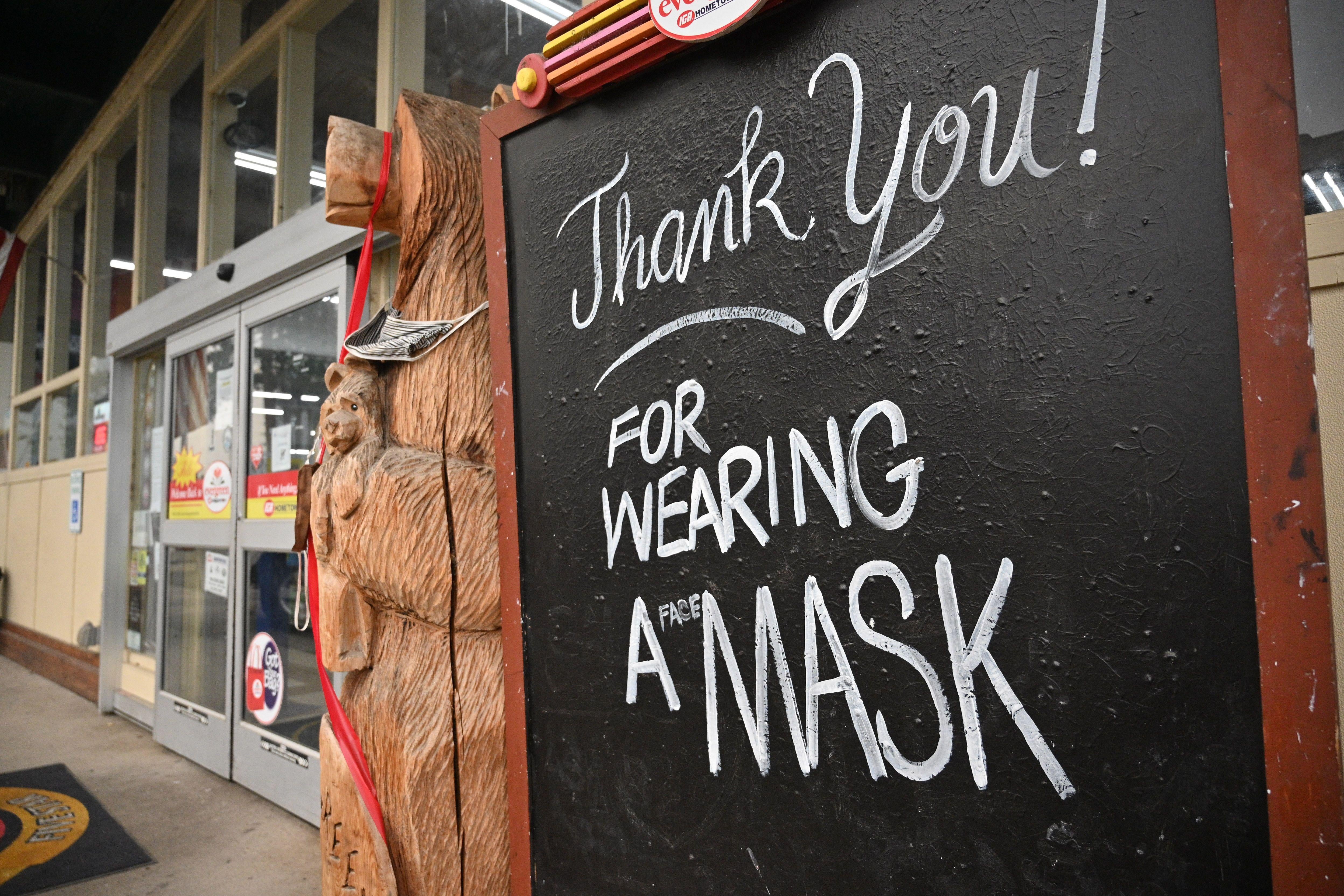 A sign reads "Thank you! For Wearing A Mask," outside a supermarket in Indian Valley, California, on July 27, 2021. 