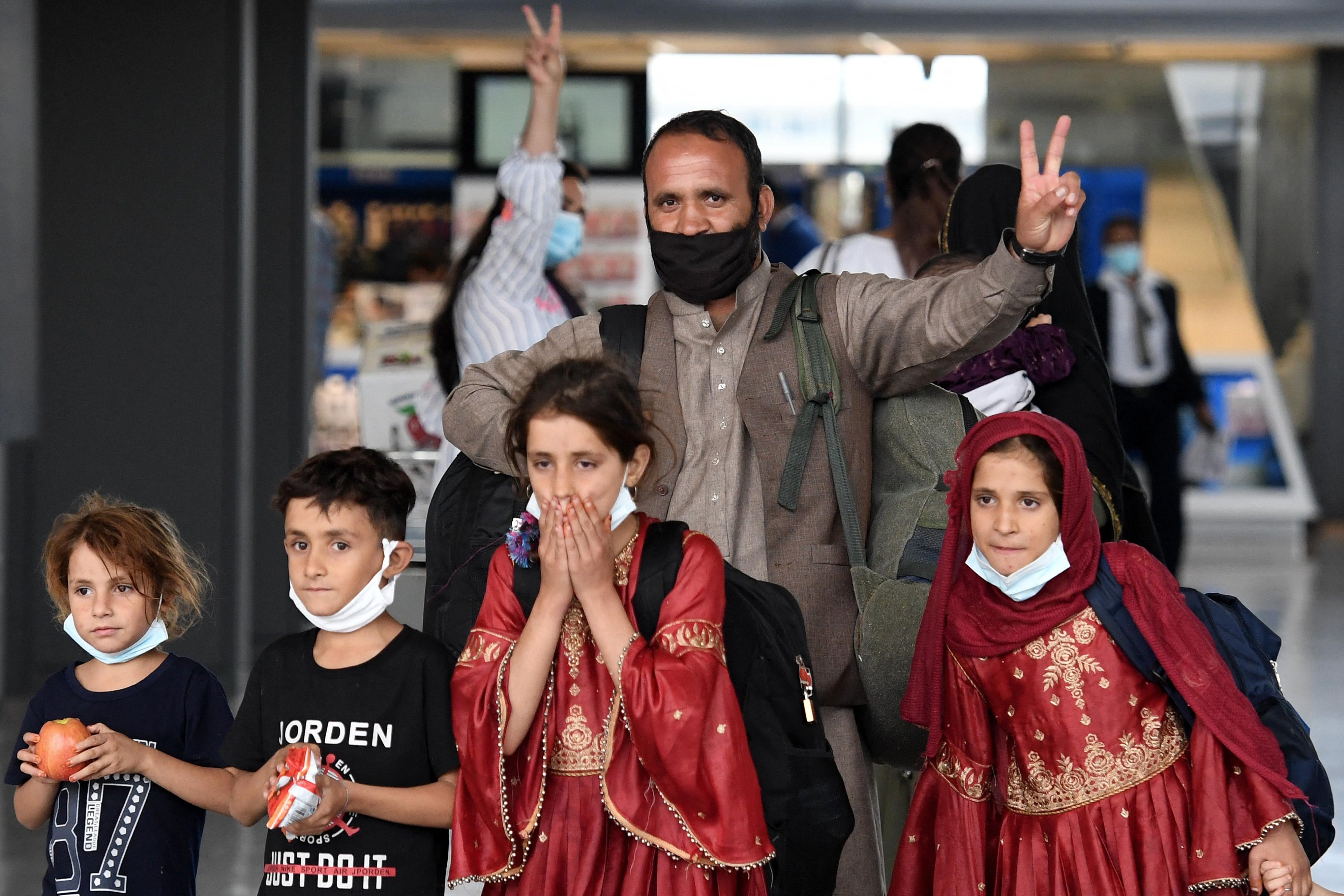 A family of Afghan refugees walks through the Dulles airport.