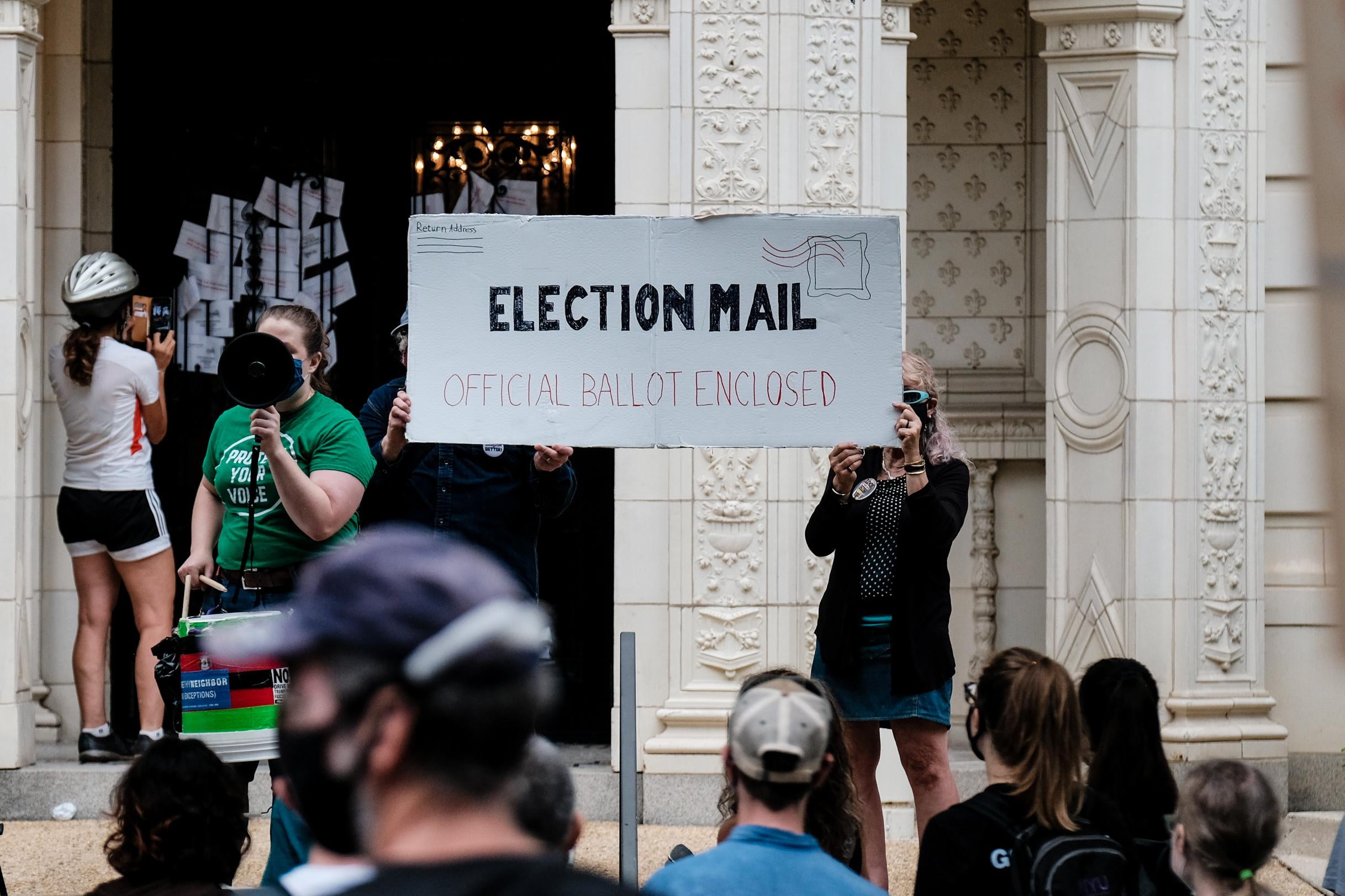 Demonstrators gather outside of the condo of President Donald Trump donor and current U.S. Postmaster General Louis Dejoy on August 15, 2020 in Washington, D.C.