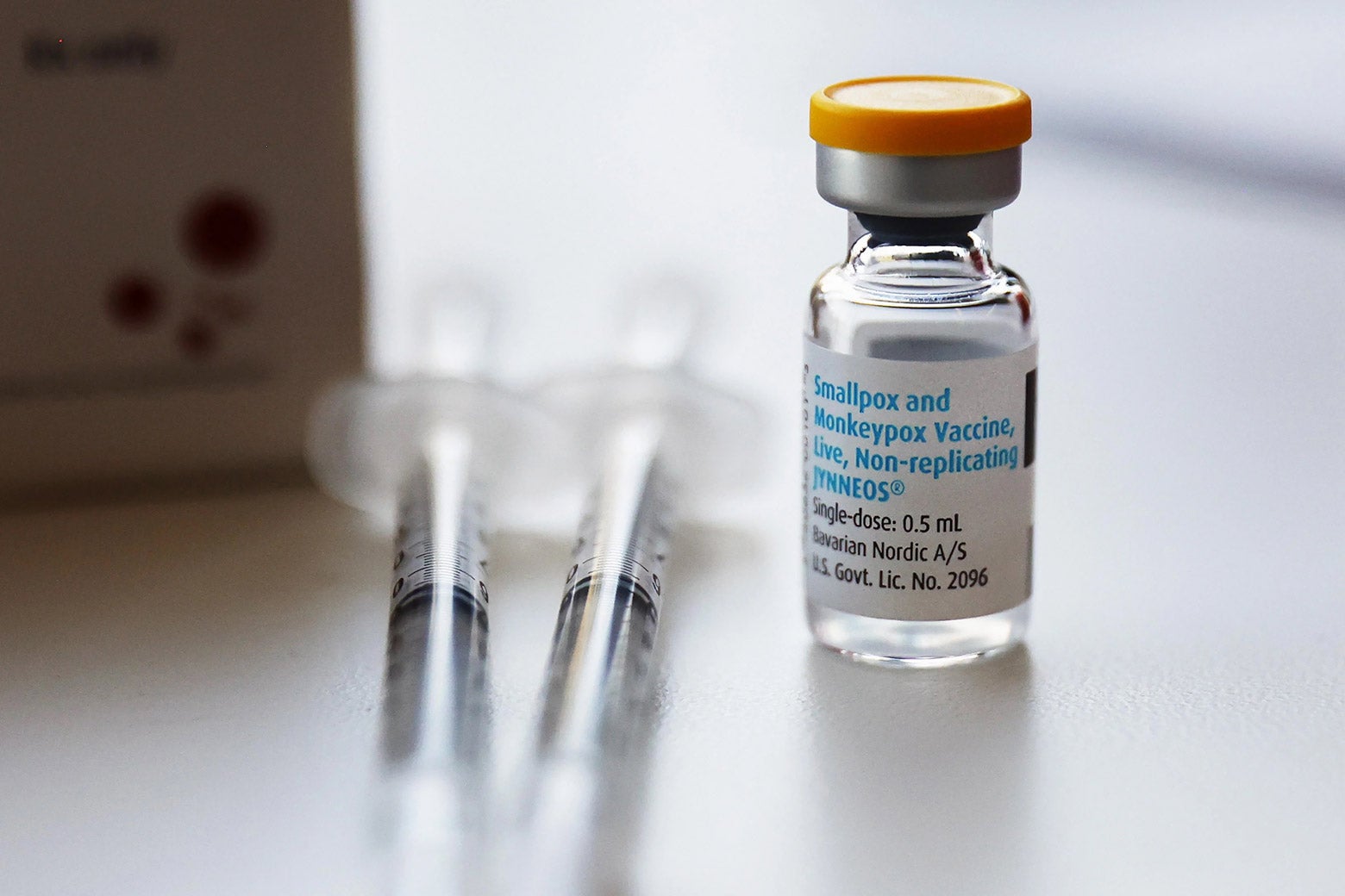 Two syringes sitting next to a vial of monkeypox vaccine.