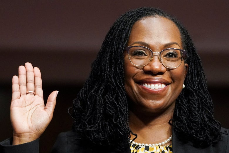 Supreme Court nominee Ketanji Brown Jackson raises her right hand and smiles.