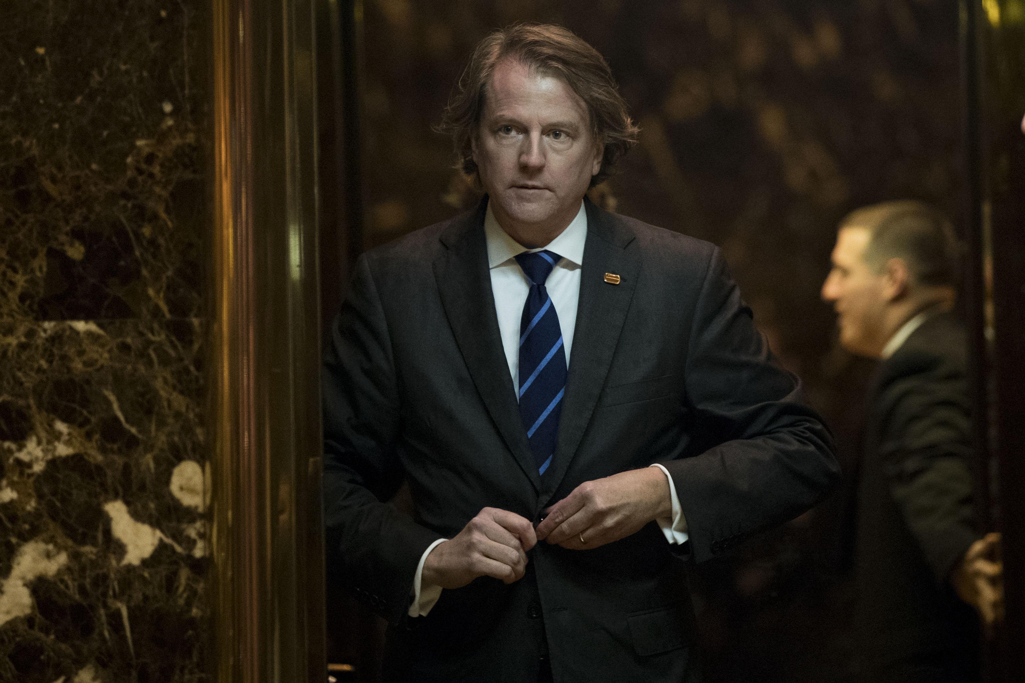 Don McGahn buttons his suit jacket as he gets into an elevator.