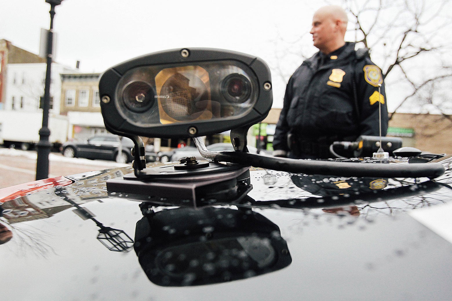 A police sergeant stands beside a cruiser equipped with an automatic license plate reader in Chelsea, Massachusetts.